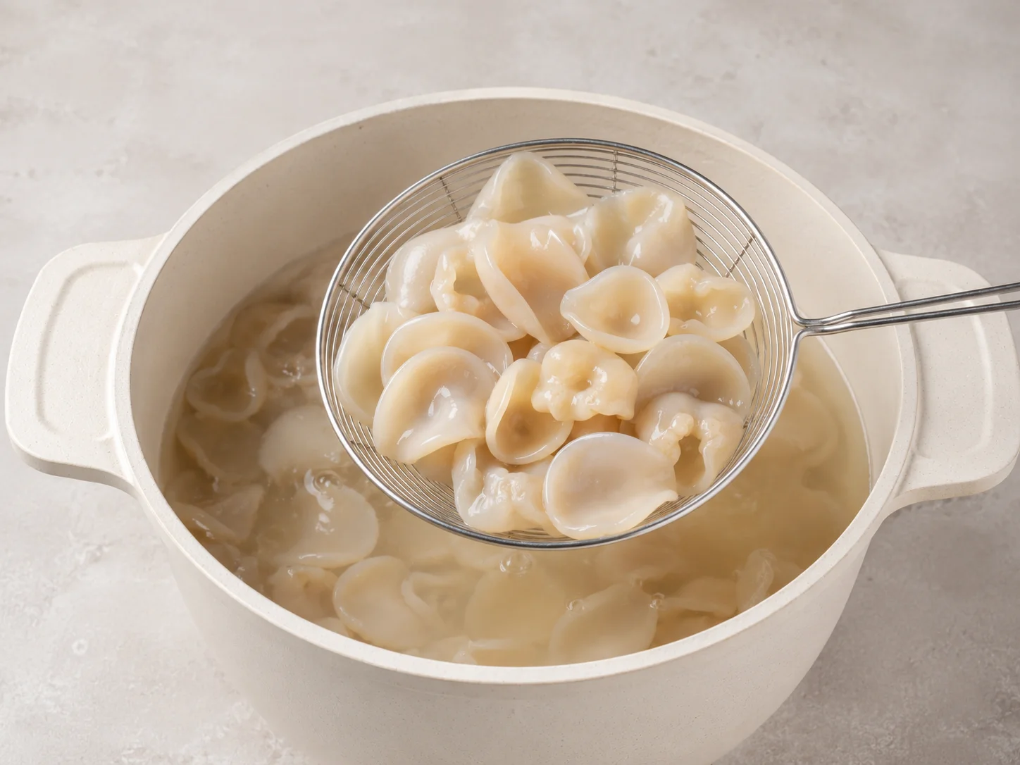 Lifting blanched jade wood ear from boiling water with a strainer